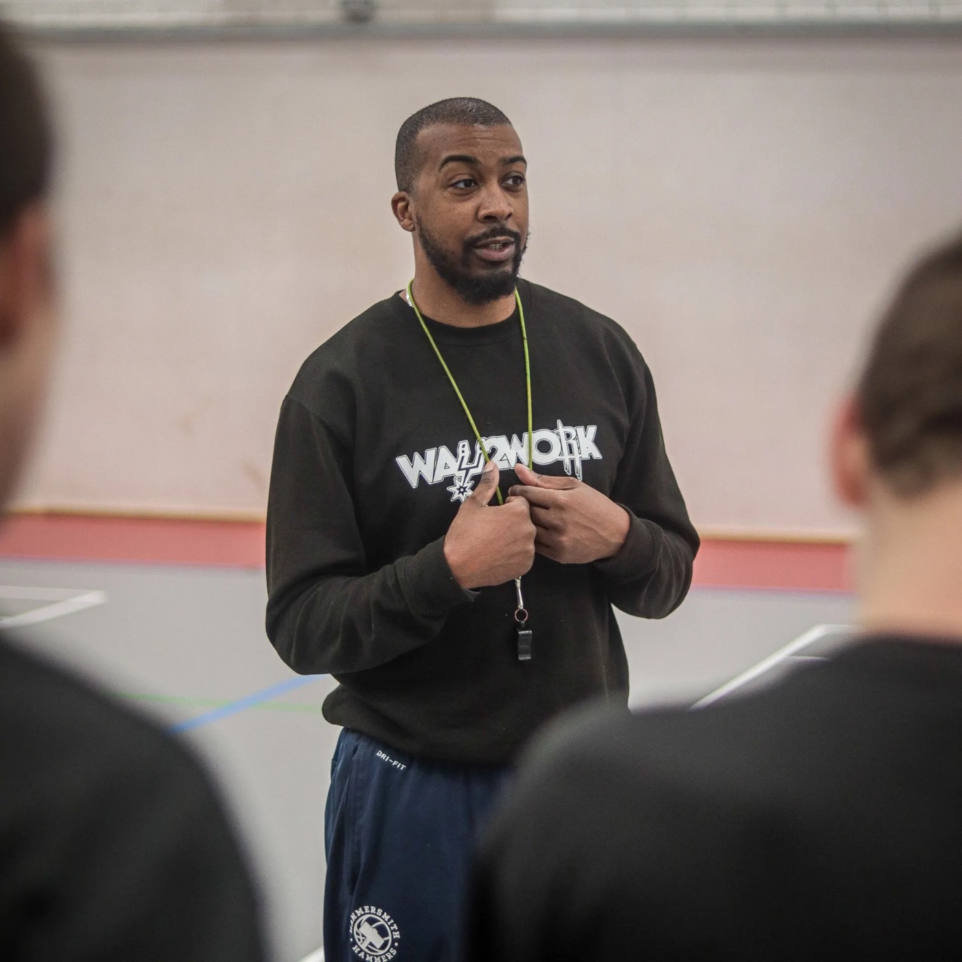 Way2Work coach in a Way2Work sweatshirt talking to his players