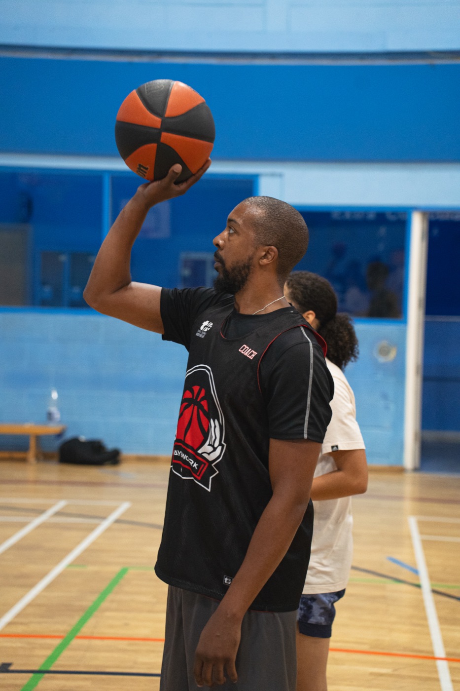 Coach demonstrating shooting form with the ball held high