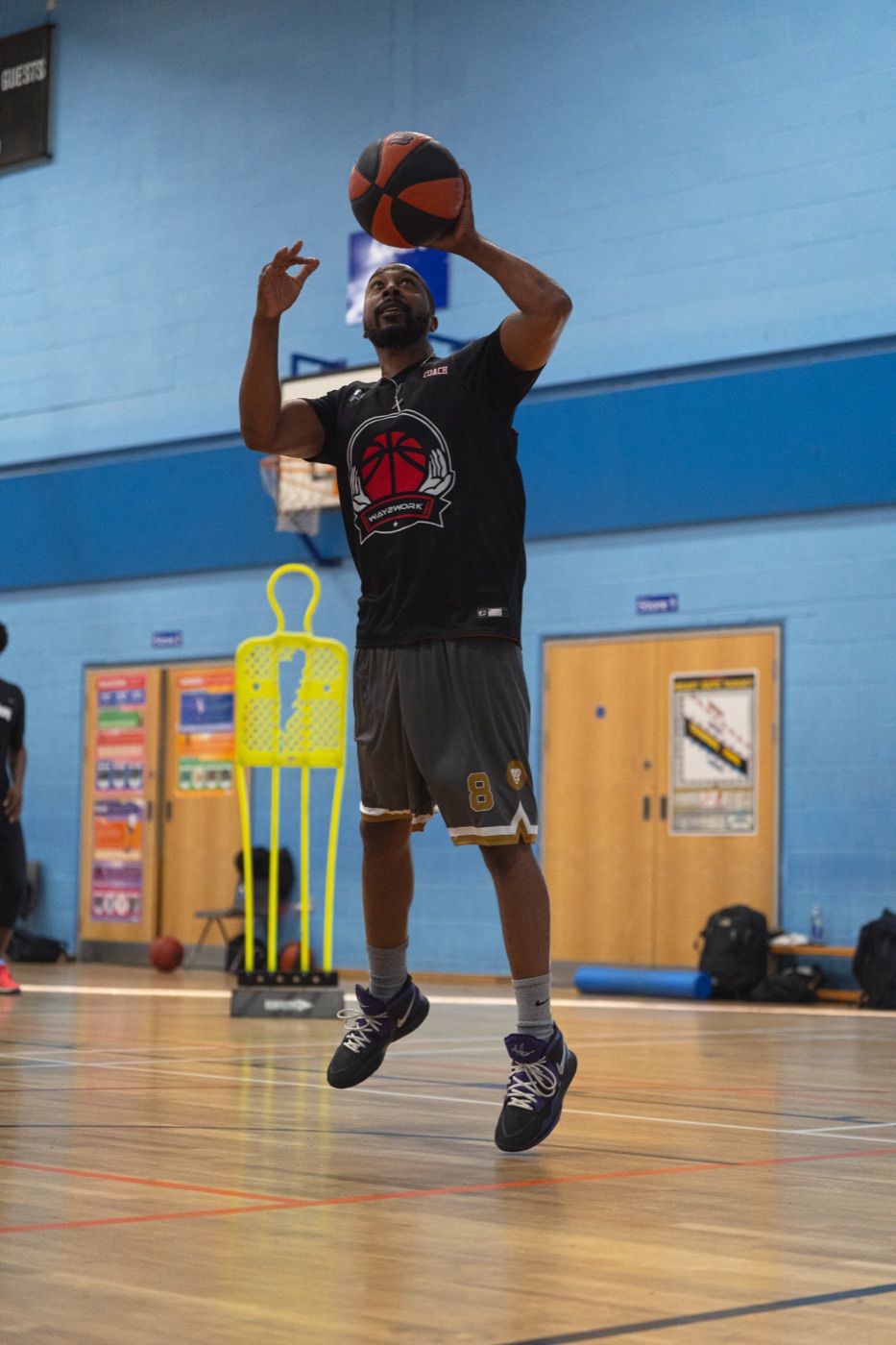 Player rising into a jump shot in a sports hall